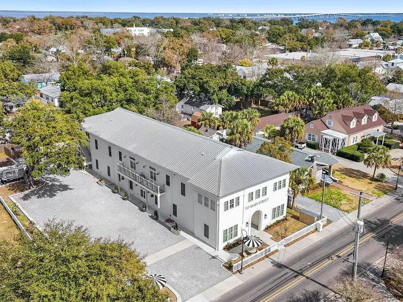 Aerial view of 315A Main Street among Old Town's oaks and rooftops, with the bay on the horizon