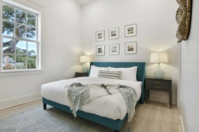 King bed beside a tall window with natural light