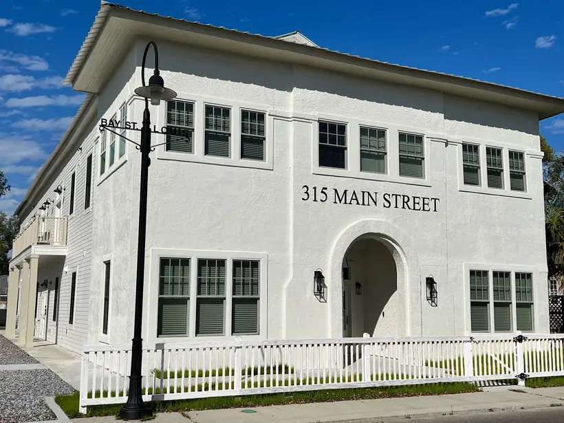 Corner view of the white 315A Main Street building with a street lamp