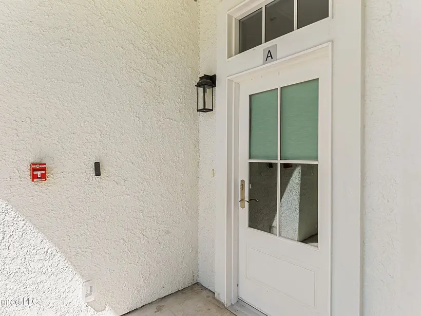 White entry door marked A with a lantern sconce