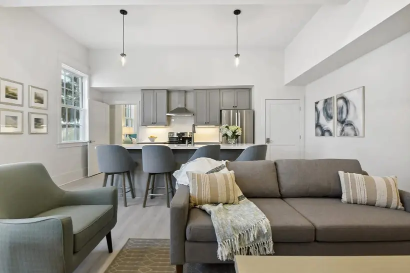 Sofa and accent chair open to the kitchen bar seating